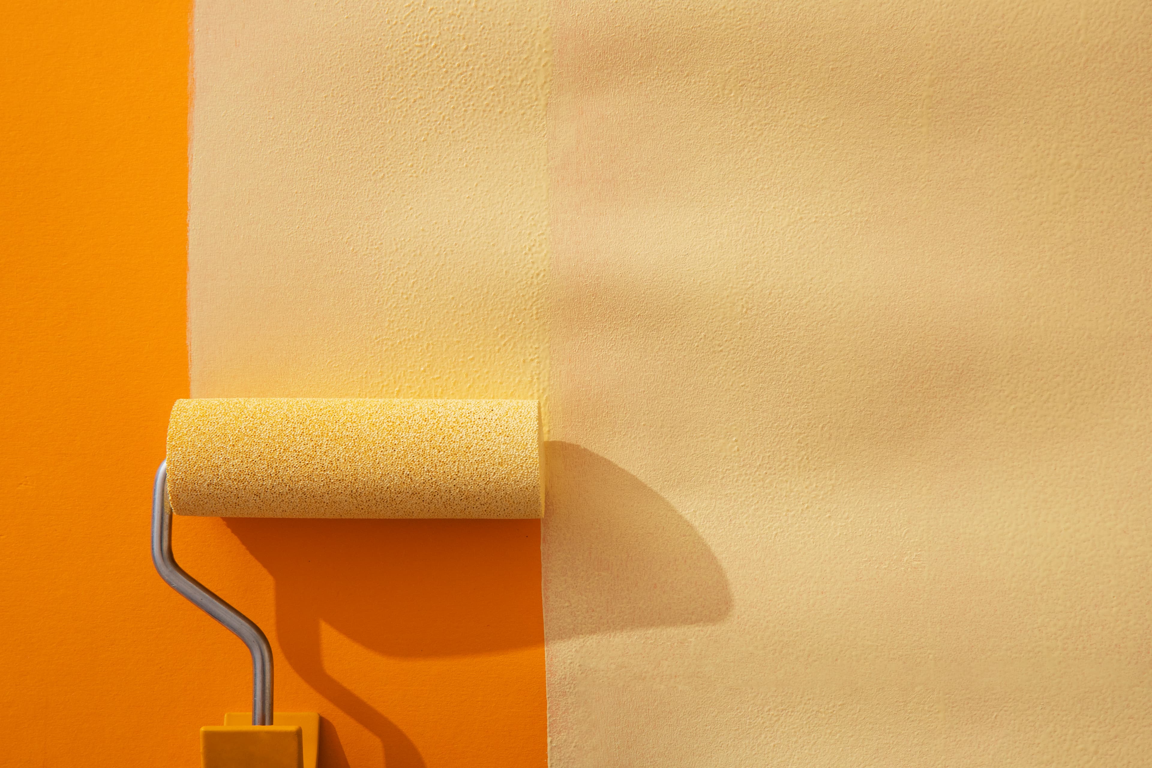 Painter applying yellow paint with brush